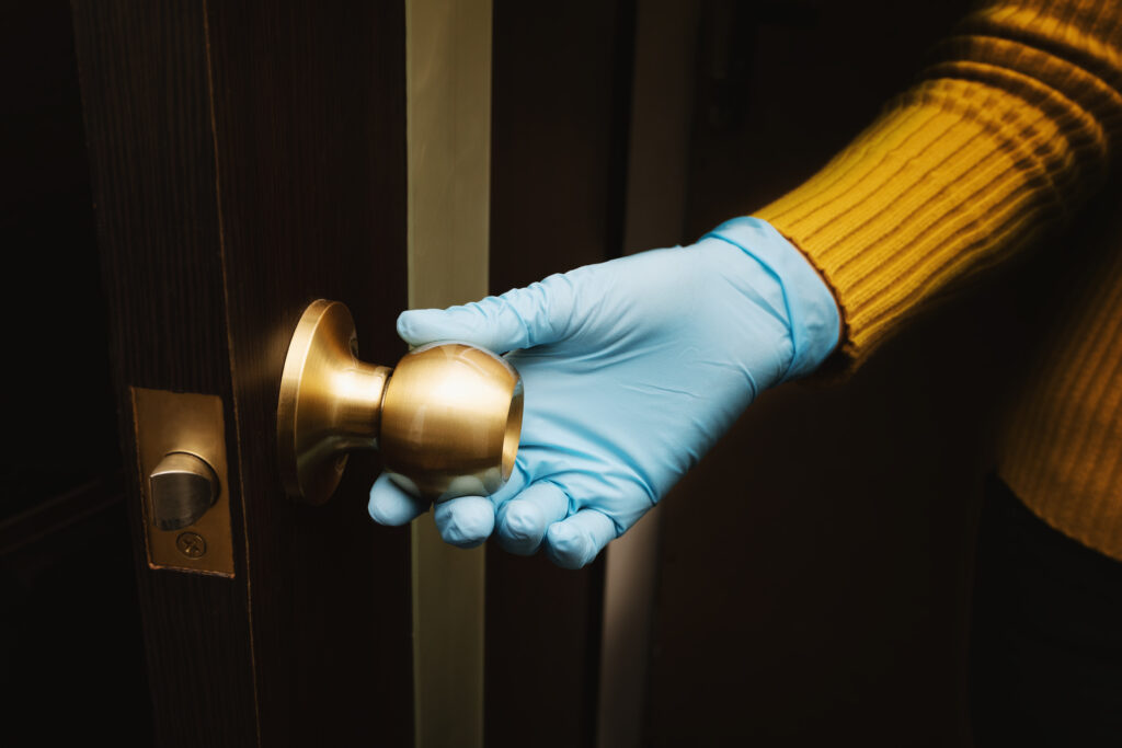 Female hand in protective glove open a door